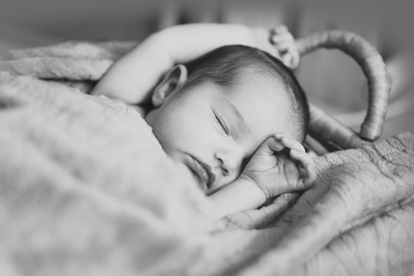 bebe durmiendo tapandose media cara de Momem Fotografia