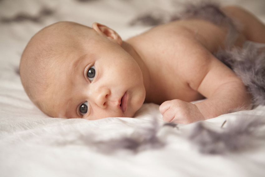 bebe sobre cama de Momem Fotografia